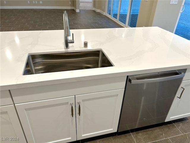 kitchen with white cabinetry, stainless steel dishwasher, and sink