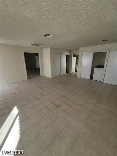 unfurnished room featuring washer / dryer and a textured ceiling