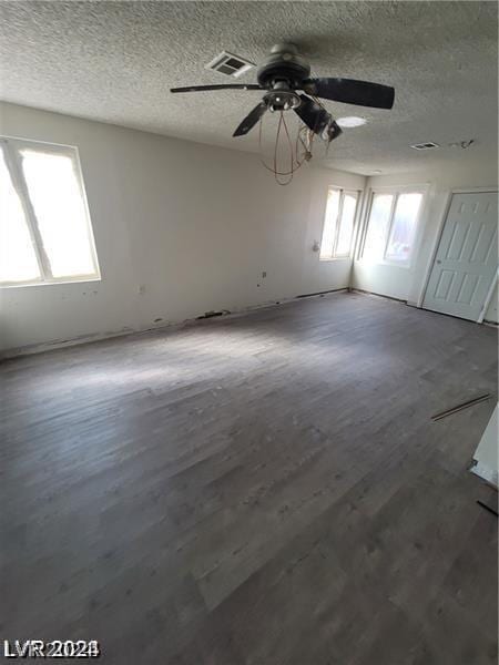 spare room featuring hardwood / wood-style flooring, ceiling fan, and a textured ceiling