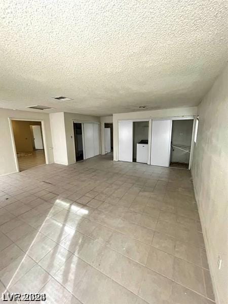 empty room featuring washer / dryer and a textured ceiling