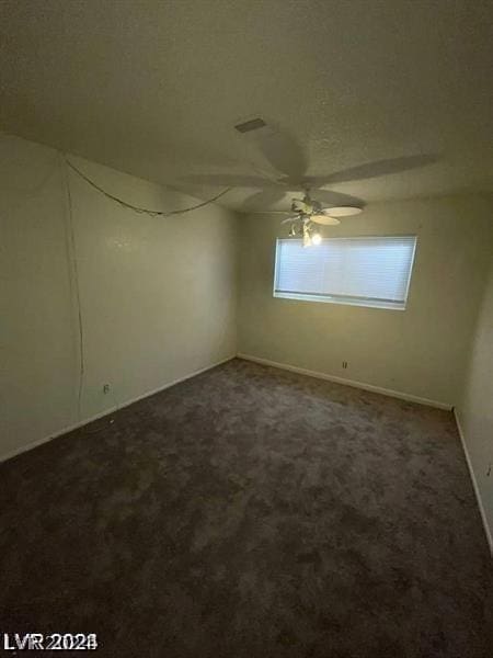 carpeted empty room featuring ceiling fan and a textured ceiling