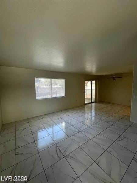 tiled empty room with ceiling fan