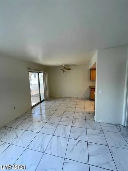 interior space with light tile patterned flooring and ceiling fan