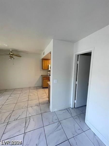 spare room featuring light tile patterned floors and ceiling fan