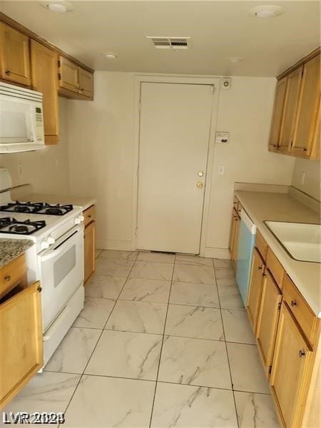 kitchen featuring sink, white appliances, and light tile patterned floors