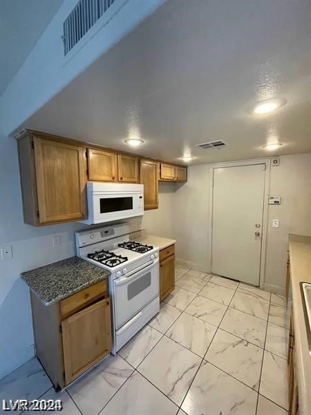 kitchen with light tile patterned floors and white appliances