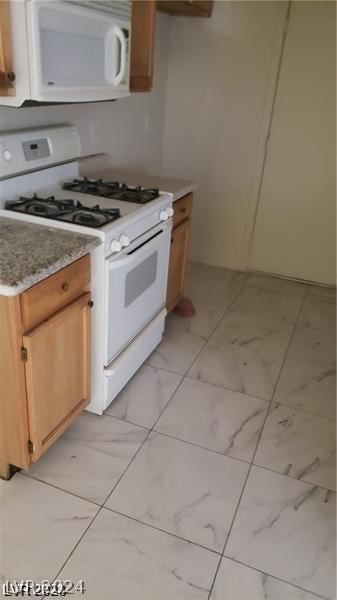 kitchen with light tile patterned floors and white appliances