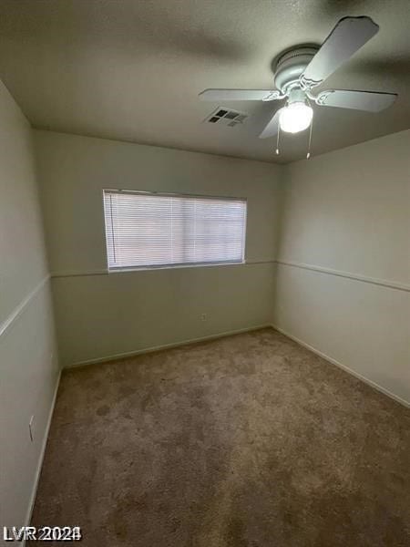 spare room with a wealth of natural light, ceiling fan, and carpet flooring