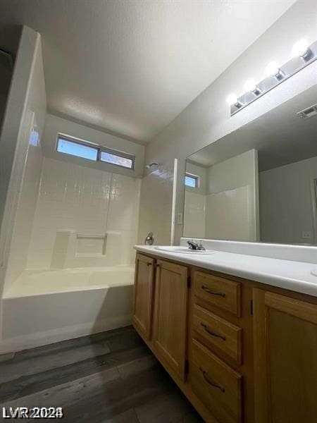 bathroom with hardwood / wood-style flooring, bathtub / shower combination, and vanity