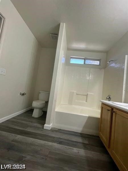 full bathroom with hardwood / wood-style floors, toilet, vanity, and tub / shower combination