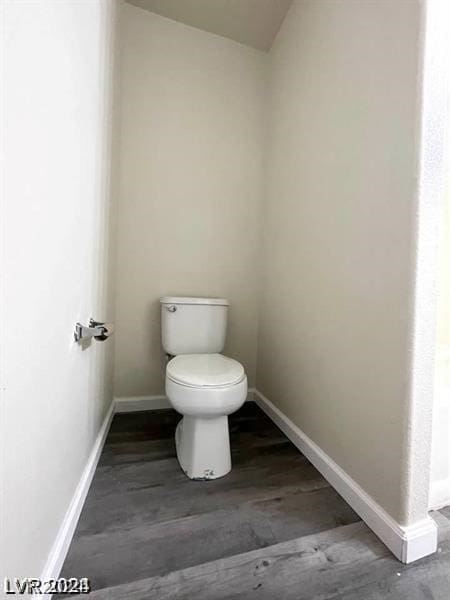 bathroom with hardwood / wood-style flooring and toilet