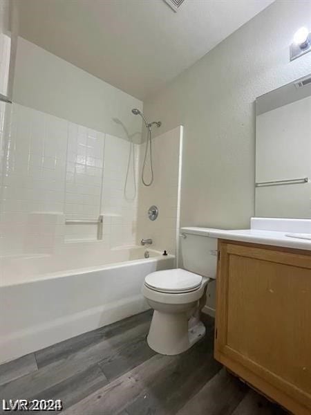 full bathroom featuring wood-type flooring, bathtub / shower combination, toilet, and vanity