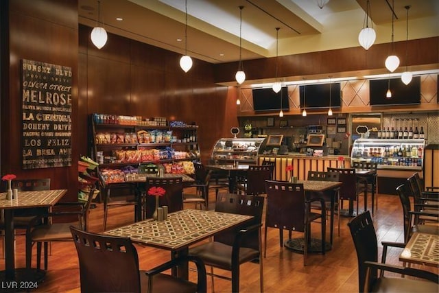 dining room featuring hardwood / wood-style flooring and wooden walls