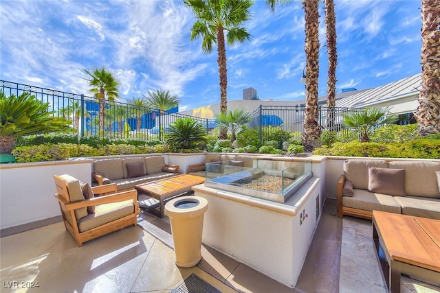 view of patio with an outdoor living space with a fire pit