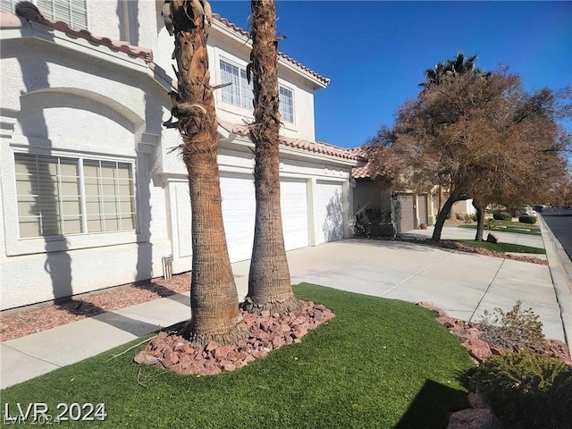 view of property exterior with stucco siding, driveway, a tile roof, and a garage