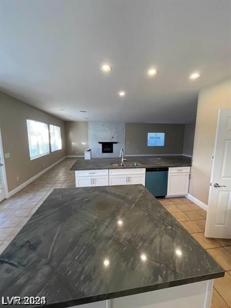 kitchen featuring sink, dishwasher, white cabinets, and light tile patterned floors