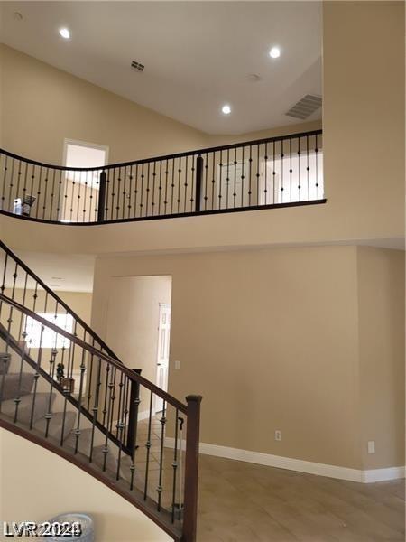 stairway featuring a towering ceiling