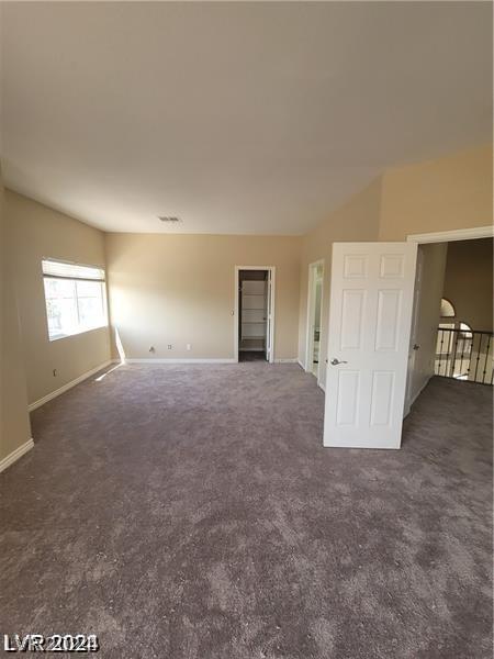 unfurnished room with dark carpet