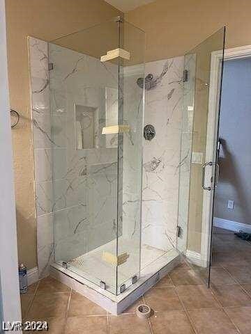 bathroom featuring a shower with door and tile patterned flooring