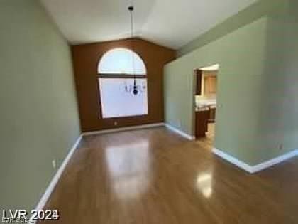 interior space with lofted ceiling, wood finished floors, and baseboards