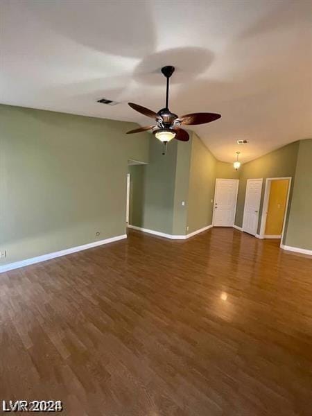 empty room featuring a ceiling fan, wood finished floors, baseboards, visible vents, and lofted ceiling