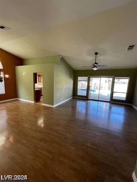 unfurnished living room featuring visible vents, lofted ceiling, dark wood-style floors, and ceiling fan with notable chandelier