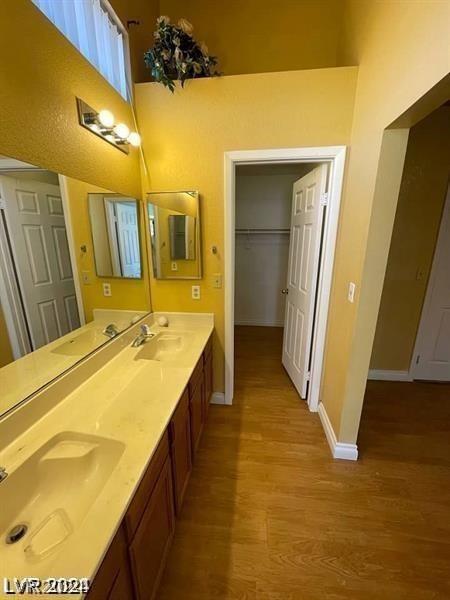 full bath with wood finished floors, baseboards, and a sink