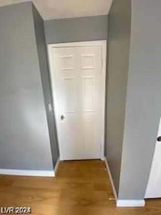 hallway with baseboards and wood finished floors