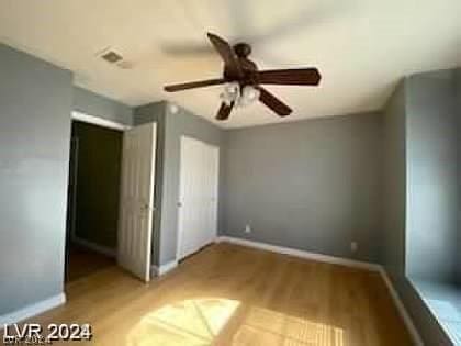 unfurnished bedroom featuring a closet, baseboards, visible vents, and a ceiling fan