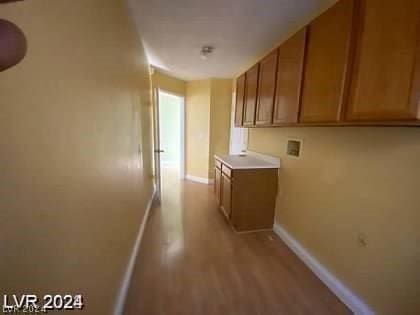 corridor with baseboards and light wood-style floors