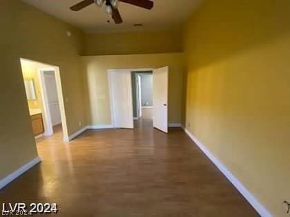 unfurnished room featuring a ceiling fan and baseboards