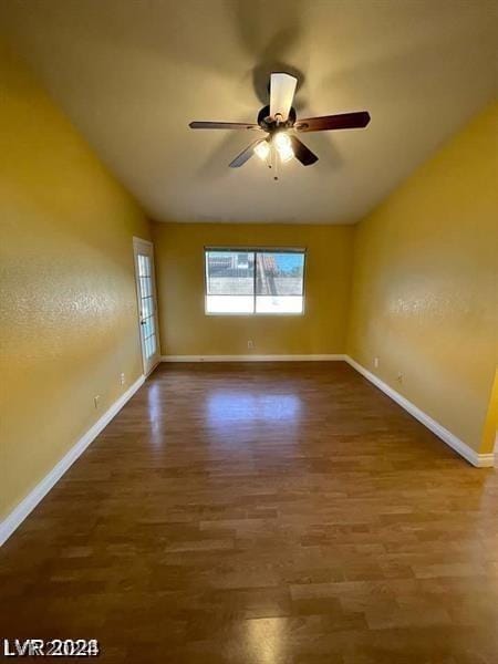 spare room with a ceiling fan, lofted ceiling, baseboards, and wood finished floors