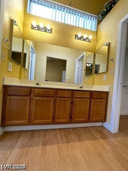 bathroom featuring vanity, wood finished floors, and a towering ceiling