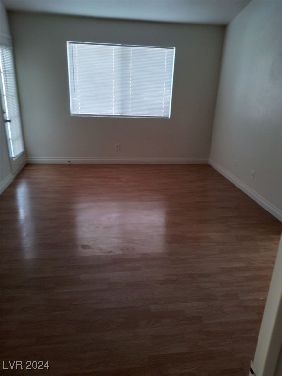 spare room with baseboards, a healthy amount of sunlight, and wood finished floors