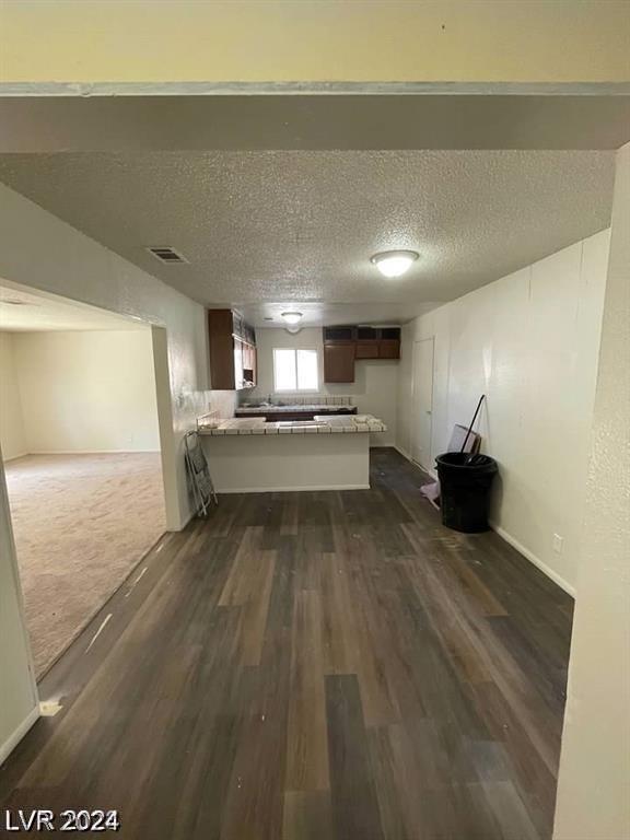 interior space featuring dark wood-type flooring and a textured ceiling