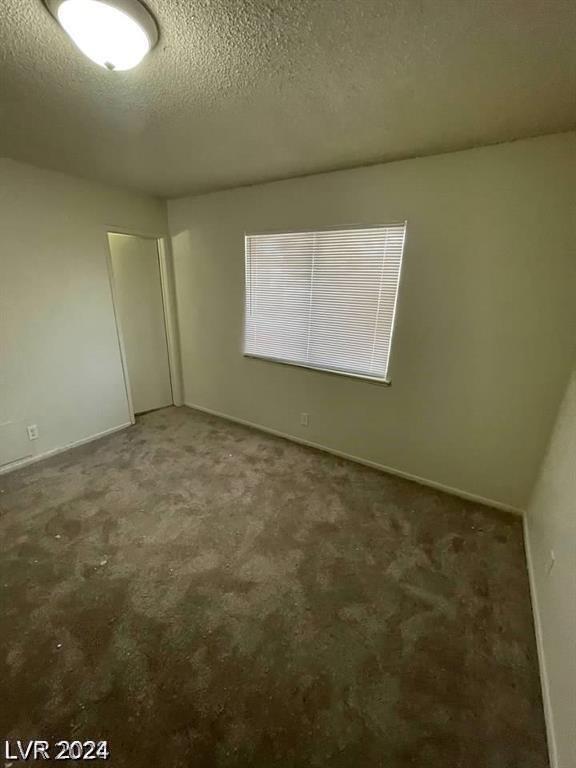 unfurnished bedroom with carpet floors and a textured ceiling