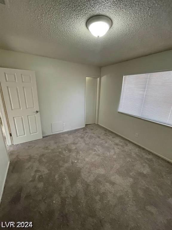 unfurnished bedroom featuring carpet floors and a textured ceiling