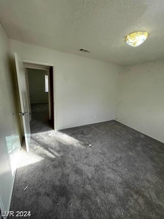 unfurnished bedroom with carpet floors and a textured ceiling