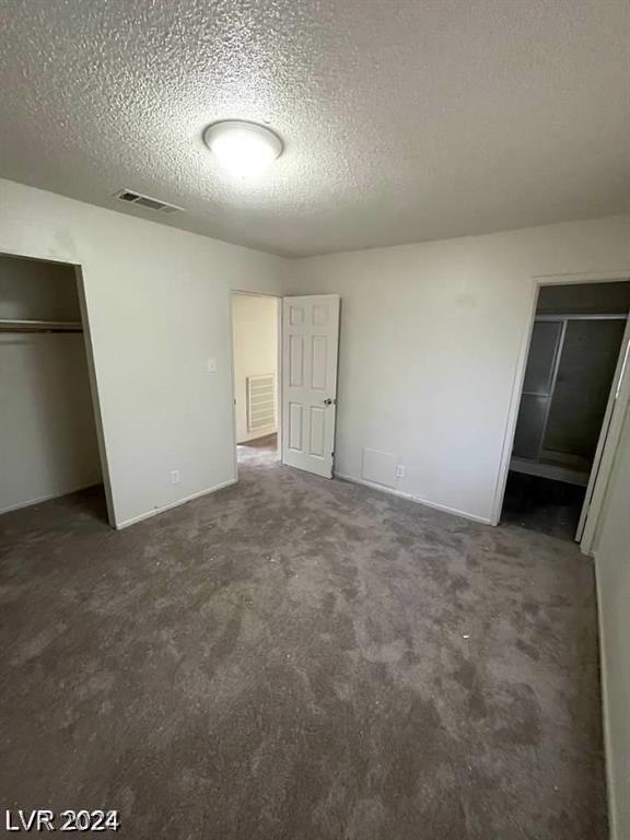 unfurnished bedroom with carpet floors and a textured ceiling