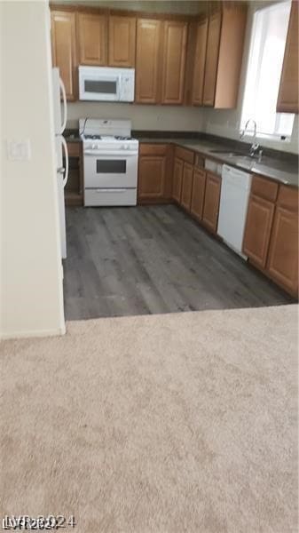 kitchen with sink, dark hardwood / wood-style floors, and white appliances