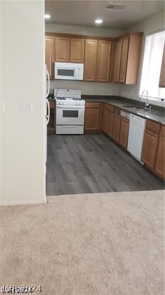 kitchen featuring sink, dark hardwood / wood-style floors, and white appliances