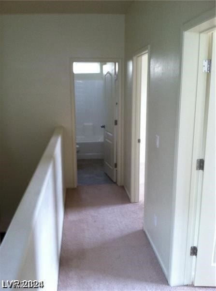 hallway with light colored carpet