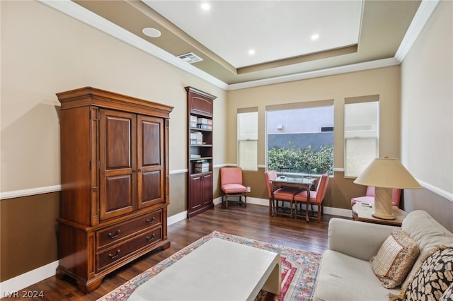 living area featuring a raised ceiling, dark wood-type flooring, and crown molding