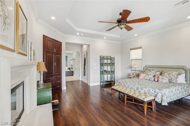 bedroom with dark hardwood / wood-style flooring, ornamental molding, a tray ceiling, and ceiling fan