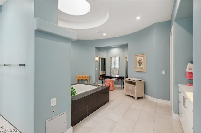 bathroom with a tray ceiling, a bath, tile patterned floors, and vanity