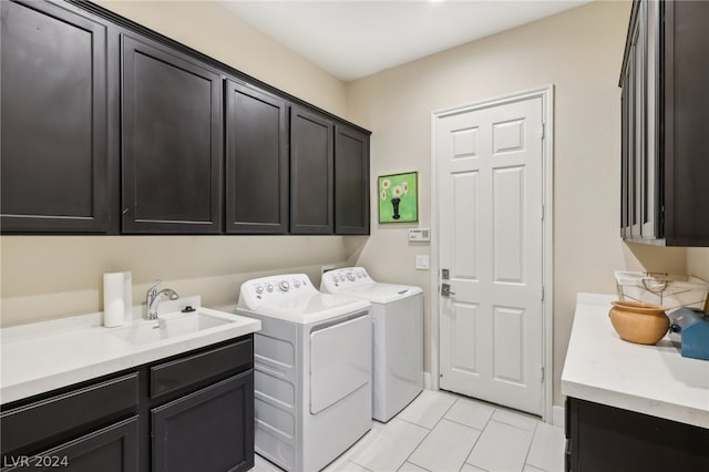 laundry area featuring washing machine and dryer, cabinets, and sink