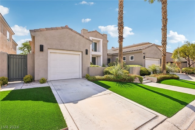 mediterranean / spanish-style house featuring a garage and a front lawn