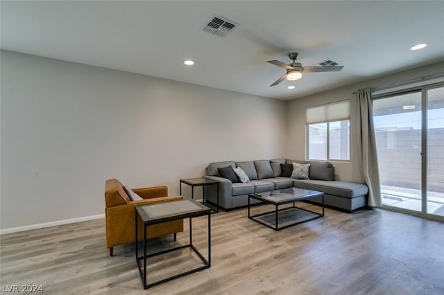 living room with ceiling fan and light hardwood / wood-style flooring