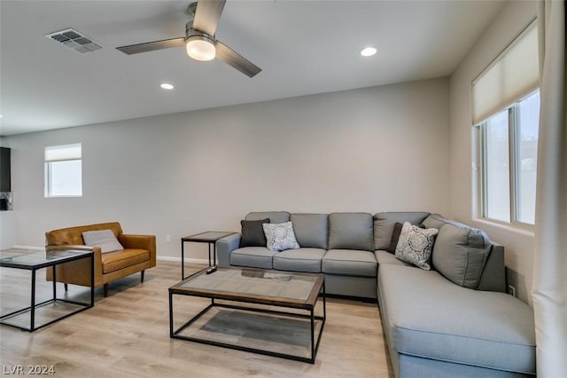 living room with light hardwood / wood-style flooring and ceiling fan