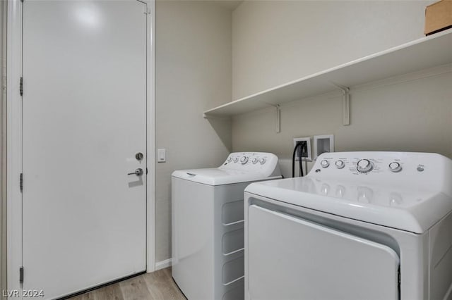 laundry area featuring washer and clothes dryer and light hardwood / wood-style floors